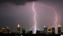 A cityscape with lightening in the background. 