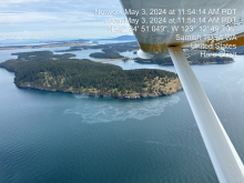 Aerial image of an island with observed oil sheen along its coast.