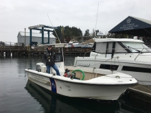 A man on a boat in a marina.