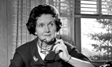 A black and white photo of a woman holding a pair of glasses.