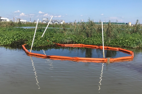 A circle of pollution boom around a spot of oil in the water.